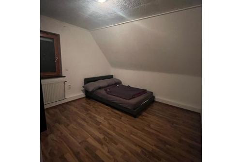 ein Schlafzimmer mit einem Bett in der Ecke eines Zimmers in der Unterkunft Private Apartment in Hannover