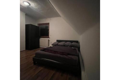 ein Schlafzimmer mit einem Bett in der Ecke eines Zimmers in der Unterkunft Private Apartment in Hannover