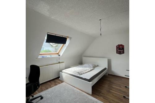 ein kleines Schlafzimmer mit einem Bett und einem Fenster in der Unterkunft Private Apartment in Hannover