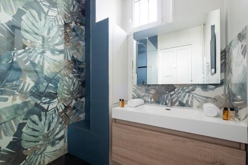 une salle de bain avec un lavabo et un miroir dans l'établissement Veeve - Parkside Innovation, à Paris