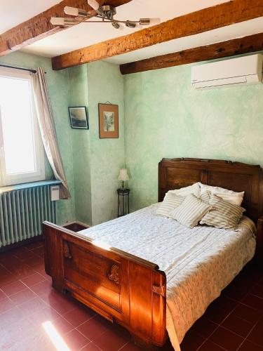 une chambre avec un lit en bois dans une pièce dans l'établissement Bastide provençale avec piscine, à Cotignac
