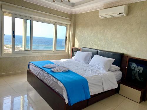 a bedroom with a bed with a view of the ocean at Luxury apartments in sanstefano in Alexandria