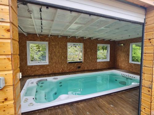 a jacuzzi tub in a house with windows at Woodview House in Elgin