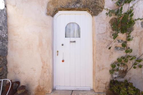 a white door in the side of a building at Alma do Paço in Santo Isidoro