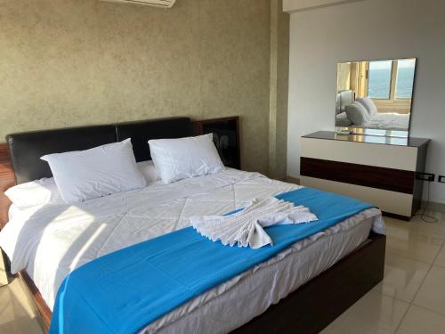a bedroom with a large bed with a blue blanket at Luxury apartments in sanstefano in Alexandria