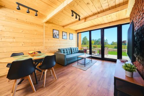 ein Wohnzimmer mit einem Tisch, Stühlen und einem Sofa in der Unterkunft Baza Dunajec Komfortowy Domek in Czarny Dunajec