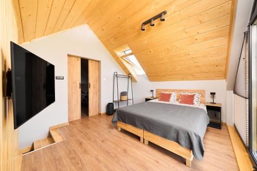 a bedroom with a bed and a flat screen tv at Baza Dunajec Komfortowy Domek in Czarny Dunajec