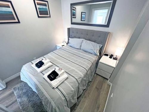 Dormitorio pequeño con cama con espejo en Hamilton Mountain Plaza - Smart Home - Main Floor, en Hamilton