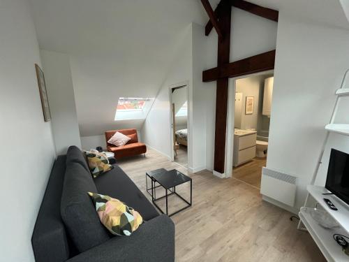 a living room with a couch and a television at duplex refait à neuf in Boulogne-sur-Mer
