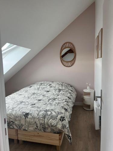 une chambre avec un lit et un miroir au mur dans l'établissement duplex refait à neuf, à Boulogne-sur-Mer