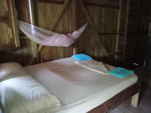 a bed in a wooden room with a net at HOSPEDAJE DOÑA NEL in El Valle