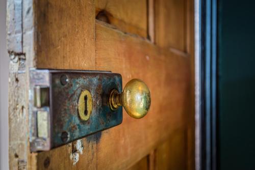 a wooden door with a brass door knocker on it at Stylish Romantic Country Escape near Chester in Christleton
