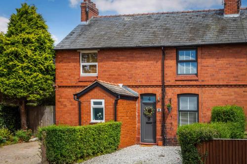 a red brick house with a black door at Stylish Romantic Country Escape near Chester in Christleton