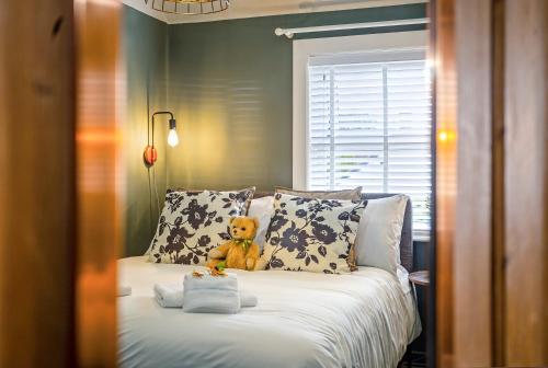a teddy bear sitting on top of a bed at Stylish Romantic Country Escape near Chester in Christleton