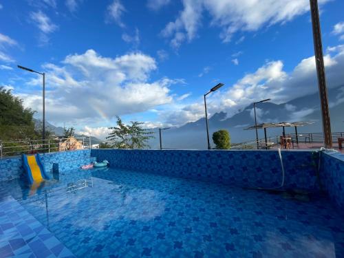 een zwembad met een blauwe lucht op de achtergrond bij Thạch Gia Trang Sapa in Sa Pa