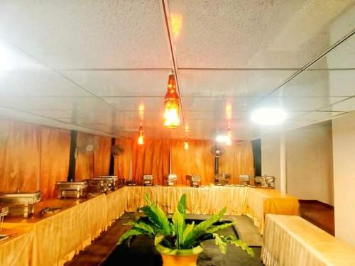 uma grande sala com mesas, cadeiras e luzes em Deliya Holiday Resort em Kamburupitiya