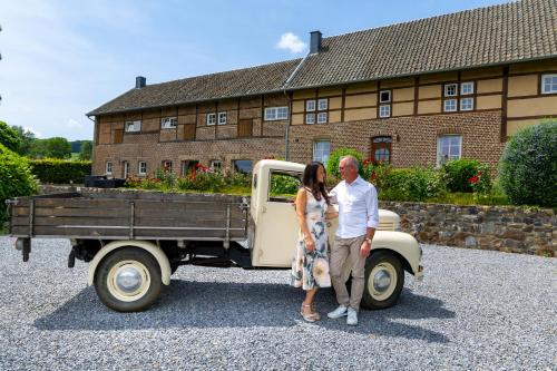 a man and a woman standing next to a truck at La belle Maison in Sippenaeken