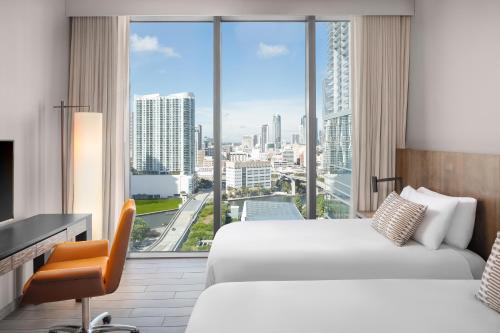a hotel room with two beds and a large window at EAST Miami in Miami