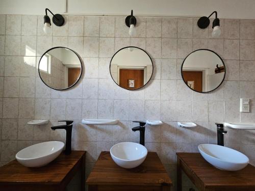 La salle de bains est pourvue de 2 lavabos et de 2 miroirs. dans l'établissement Yellow House Cottage, à El Chalten