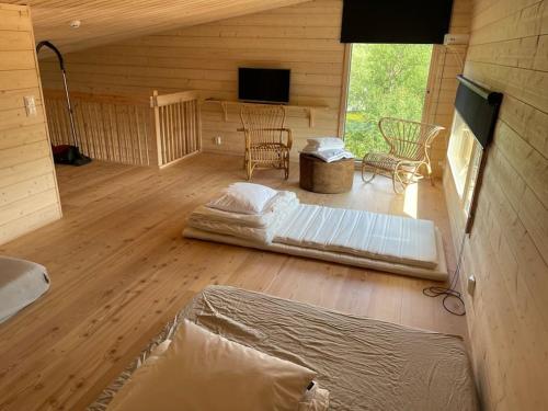 a room with two beds in a wooden cabin at Villa Aitti in Utsjoki