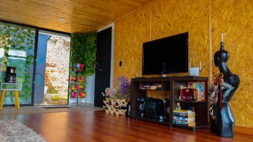 a living room with a television and a wooden floor at Meraki_Paipa in Paipa