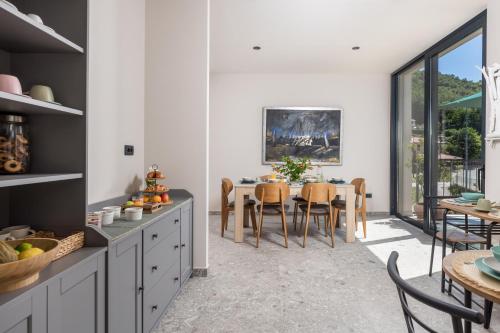 a kitchen with a dining room with a table and chairs at PERUNIKA BED & BREAKFAST in Mošćenička Draga