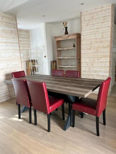 d'une table à manger entourée de chaises rouges. dans l'établissement KEUR FOFO, à Dolus-d'Oléron