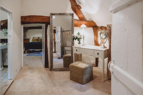 une chambre avec un miroir, une coiffeuse et un lit dans l'établissement Laundry Cottage, à Loughborough