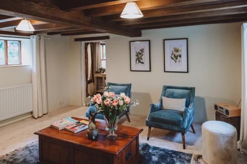 un soggiorno con un vaso di fiori su un tavolo di Laundry Cottage a Loughborough