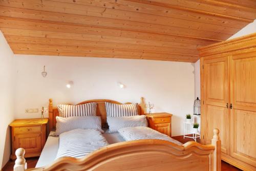 a bedroom with a large wooden bed with two pillows at Ferienwohnung Kramernest in Grainau
