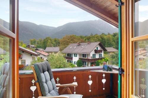 a balcony with a chair and a view of mountains at Ferienwohnung Kramernest in Grainau
