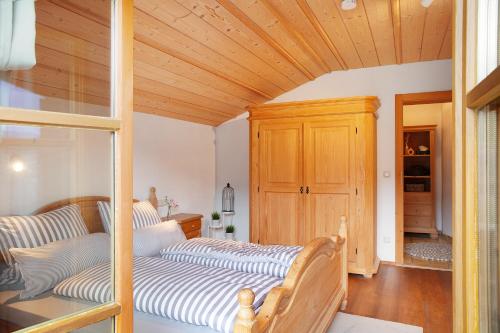a bedroom with two beds and a wooden ceiling at Ferienwohnung Kramernest in Grainau