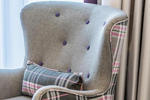 a chair with purple buttons on it with a pillow at Premier Inn Leipzig City Hahnekamm in Leipzig