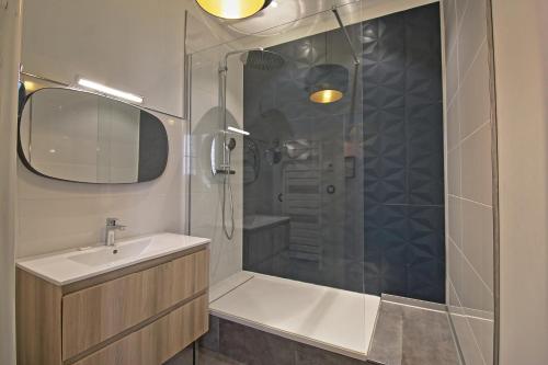 a bathroom with a tub and a sink and a shower at Le Sensas - Climatisation et Centre in Nîmes