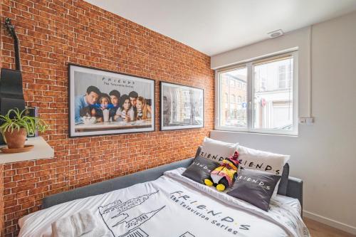 - une chambre avec un mur en briques, un lit et deux fenêtres dans l'établissement ExploreReims - the Friendliest place proche gare et centre, à Reims