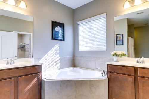 uma casa de banho com uma banheira, 2 lavatórios e um espelho. em Gibsonton Vacation Rental with Private Patio! em Gibsonton