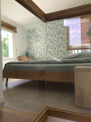 um quarto com uma cama com uma parede de vidro em Maison du Saleys em Salies-de-Béarn
