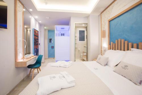 a bedroom with a large white bed and a blue wall at Mariet Athens Boutique Spa in Athens