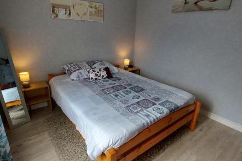 - un lit dans une chambre avec 2 lampes sur 2 tables dans l'établissement La Courtoisie maison de vacances proche plage, à Saint-Malo