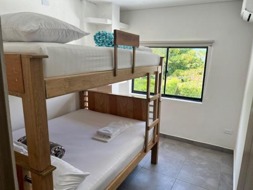 ein paar Etagenbetten in einem Zimmer mit Fenster in der Unterkunft Hermosa cabaña en sopetran in Sopetran