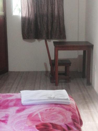 a bedroom with a bed and a desk and a table at Candurumy Lodge in Tena
