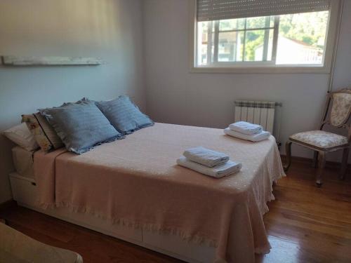 1 dormitorio con 1 cama con 2 toallas en Tranquilidad y Naturaleza, en Mondariz-Balneario