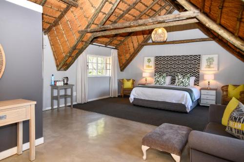 a bedroom with a king sized bed and a couch at Gowan Valley Guest Farm in Balgowan