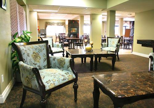 un hall avec des chaises, une table et une table sidx sidx sidx dans l'établissement The Medicine Hat Villa, à Medicine Hat