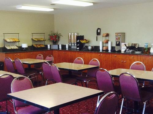 a dining room with tables and purple chairs at Super 8 by Wyndham West Kelowna BC in West Kelowna