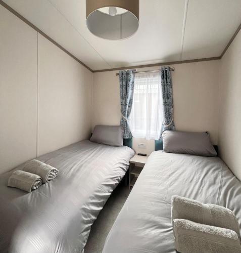 Woodview Retreat : سريرين في غرفة صغيرة مع نافذة