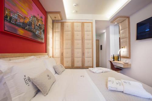 a bedroom with a white bed with a red wall at Mariet Athens Boutique Spa in Athens