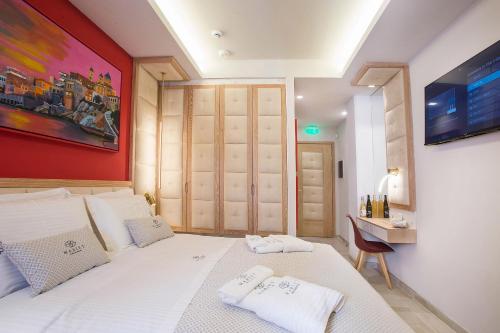 a bedroom with a white bed and a red wall at Mariet Athens Boutique Spa in Athens