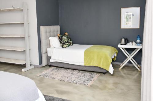 a bedroom with a bed with a yellow blanket at Gowan Valley Guest Farm in Balgowan