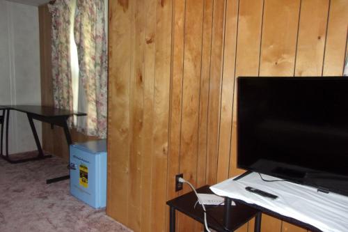 un salon avec une télévision et une table avec une table dans l'établissement NiceShortStayMassena, à Massena